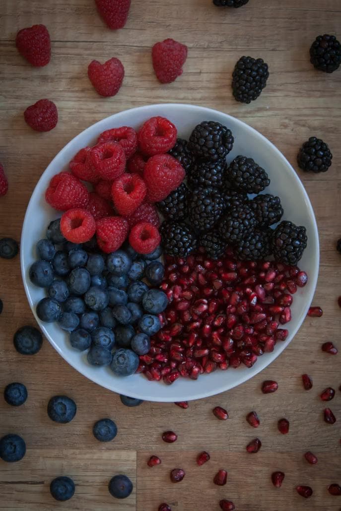 A bowl of fruits with antioxidants. Raspberries, blackberries, blueberries, and pomegranate.